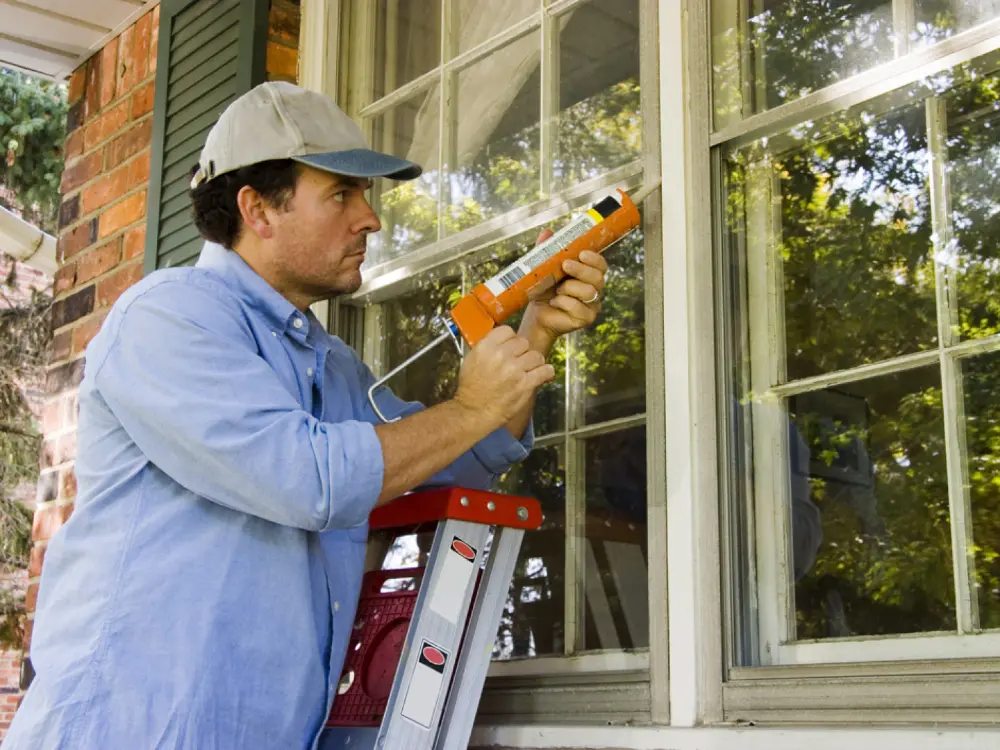 Man caulking window